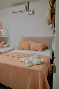two beds in a room with towels on the bed at Casa Belén in Flores