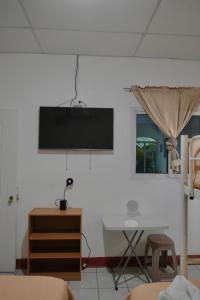 a living room with a tv on a white wall at Casa Belén in Flores