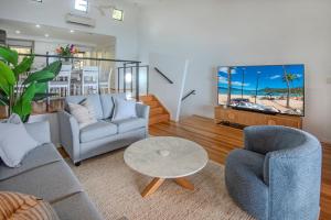 a living room with a couch and chairs and a table at Shorelines Apartments on Hamilton Island by HIHA in Hamilton Island