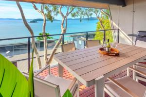 a table and chairs on a balcony with a view of the ocean at Shorelines Apartments on Hamilton Island by HIHA in Hamilton Island