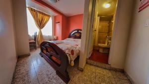 a bedroom with orange walls and a bed in a room at Hostal La Rosa Otavalo in Otavalo +87 photos