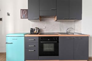 a kitchen with a stove and a blue refrigerator at CasaTella Rose in Suite in Rosate +18 photos