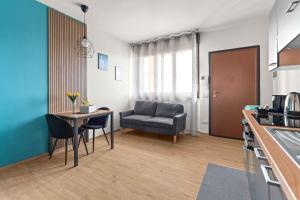 a kitchen and living room with a table and a chair at CasaTella Rose in Suite in Rosate