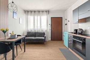 a kitchen and living room with a couch and a table at CasaTella Rose in Suite in Rosate