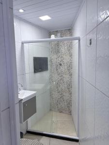 a white bathroom with a shower and a sink at The Brooklyn One in Salvador