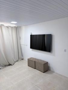 a flat screen tv hanging on a white wall at The Brooklyn One in Salvador