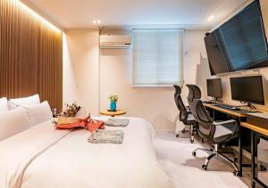 a bedroom with a bed and a desk with a computer at No25 Doksan Intersection in Seoul +56 photos