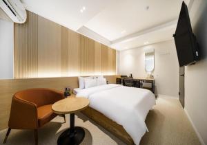 a bedroom with a bed and a table and a chair at No25 Doksan Intersection in Seoul