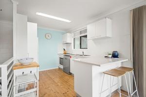 a kitchen with white cabinets and a counter top at At The Beach in Lennox Head