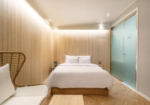 a bedroom with a large white bed and a couch at No25 Doksan Intersection in Seoul