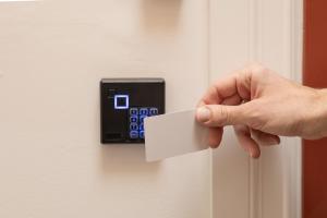 a hand unlocking a door with a white card at Auberge Le Treehouse in Montreal