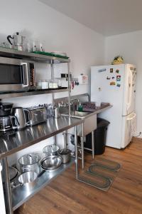 a kitchen with stainless steel appliances and a white refrigerator at Auberge Le Treehouse in Montreal +17 photos