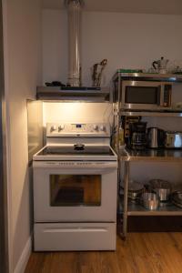 a kitchen with a white stove and a microwave at Auberge Le Treehouse in Montreal