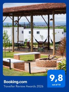 a pavilion with tables and chairs in a park at Noite Estrelada Hospedagem Rural & Motorhome Park in Holambra