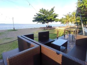 a balcony with a table and chairs and the beach at Seaview Beach Resort Dumaguete Beachfront in Sibulan