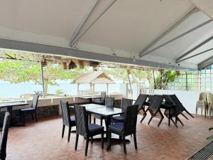 a group of tables and chairs in a restaurant at Seaview Beach Resort Dumaguete Beachfront in Sibulan