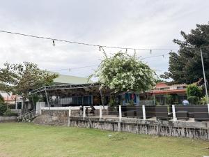 a building with a fence in front of a yard at Seaview Beach Resort Dumaguete Beachfront in Sibulan