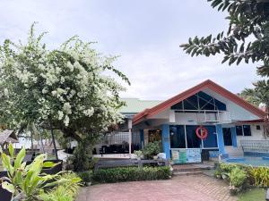 a building with a flowering tree in front of it at Seaview Beach Resort Dumaguete Beachfront in Sibulan +88 photos