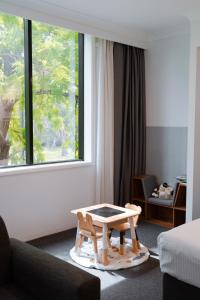 a living room with a coffee table in front of a window at The Select Inn Penrith in Penrith