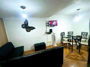 a living room with a couch and a table with a butterfly on the wall at Rent Casa La Moraleja in Ixtapa