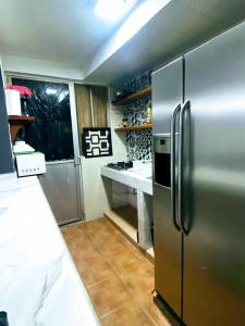 a kitchen with a stainless steel refrigerator at Rent Casa La Moraleja in Ixtapa