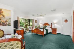 a bedroom with a bed and a living room at Mountain Sanctuary Retreat in Mount Tamborine
