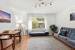 a living room with a blue couch and a table at Mountain Sanctuary Retreat in Mount Tamborine