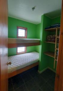 a small room with green walls and bunk beds at Cabañas Alquymia in Algarrobo