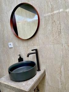 a bathroom sink with a large mirror on a wall at Adisamasta Guesthouse in Sidemen