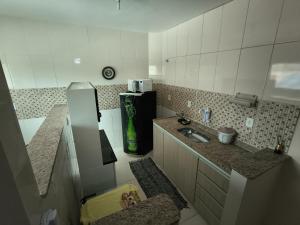 a small kitchen with a sink and a refrigerator at Casa e Mar Apto aconchegante perto da praia com estacionamento in São Pedro da Aldeia +6 photos
