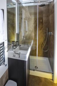 ein Bad mit einer Dusche, einem Waschbecken und einem WC in der Unterkunft Click&Sleep Fuorigrotta in Neapel