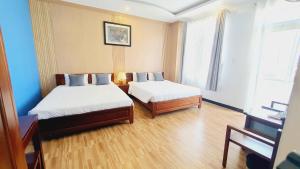 a hotel room with two beds and a piano at Khách sạn Minh Quang in Phan Rang–Tháp Chàm