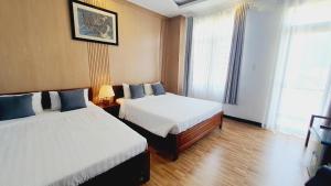 a hotel room with two beds and two windows at Khách sạn Minh Quang in Phan Rang–Tháp Chàm +18 photos