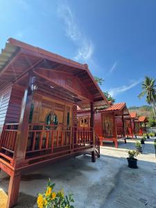 a small wooden building with a porch on a beach at Lamphu Resort Koh Lanta at Lanta Old Town in Ko Lanta