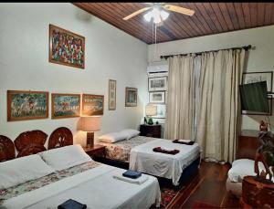 a bedroom with two beds and a television in it at Hillcrest Sanctuary in Maraval +54 photos