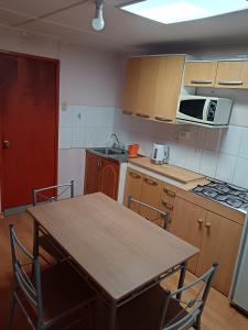 a kitchen with a table and chairs and a microwave at Casa de alojados in Antofagasta +12 photos