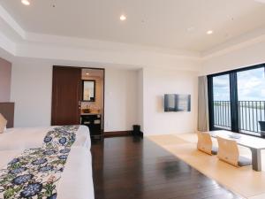 a hotel room with a bed and a desk at Senagajima Island Resort & Spa in Tomigusuku