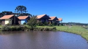 a group of houses next to a river at Quinta da Soliran Chalés Rural in Cambará
