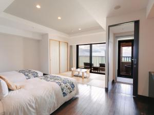 a bedroom with two beds and a balcony at Senagajima Island Resort & Spa in Tomigusuku