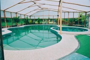 a swimming pool under a tent with a swimming pool at Las Orquídeas Runtun Lodge in Baños