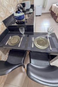 a black table with two plates and silverware on it at Aeroporto e praia Studio Casal in Vitória +10 photos