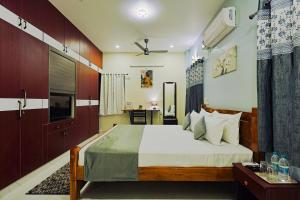 a bedroom with a large bed and a desk at Aashi-Premium Serviced Apartments in Chennai
