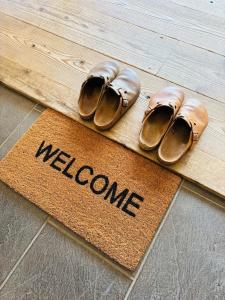 a welcome mat with a pair of shoes and a welcome mat at HIKE Hayama愛犬と過ごす葉山のマウンテンビュー大人定員4名 in Hayama +80 photos