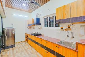 a large kitchen with wooden cabinets and a sink at Aashi-Premium Serviced Apartments in Chennai