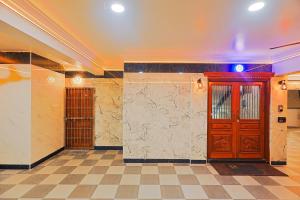 a lobby with two wooden doors and a tiled floor at Aashi-Premium Serviced Apartments in Chennai