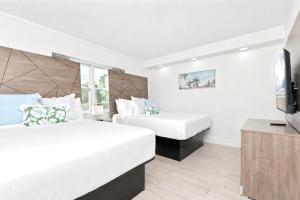 a hotel room with two beds and a flat screen tv at Fin's Inn & Suites in Myrtle Beach +38 photos