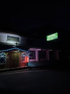 a hotel building with a neon sign in the dark at Hotel Buro The Gate in Kalpa +16 photos