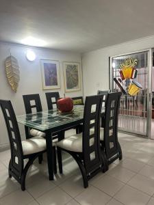 a dining room with a glass table and chairs at Casa Cortijos in Valledupar