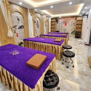 a row of tables in a room with purple table cloth at SanTran Hotel and Spa in Hai Phong