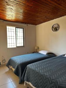 a bedroom with two beds and a wooden ceiling at Casa Cortijos in Valledupar